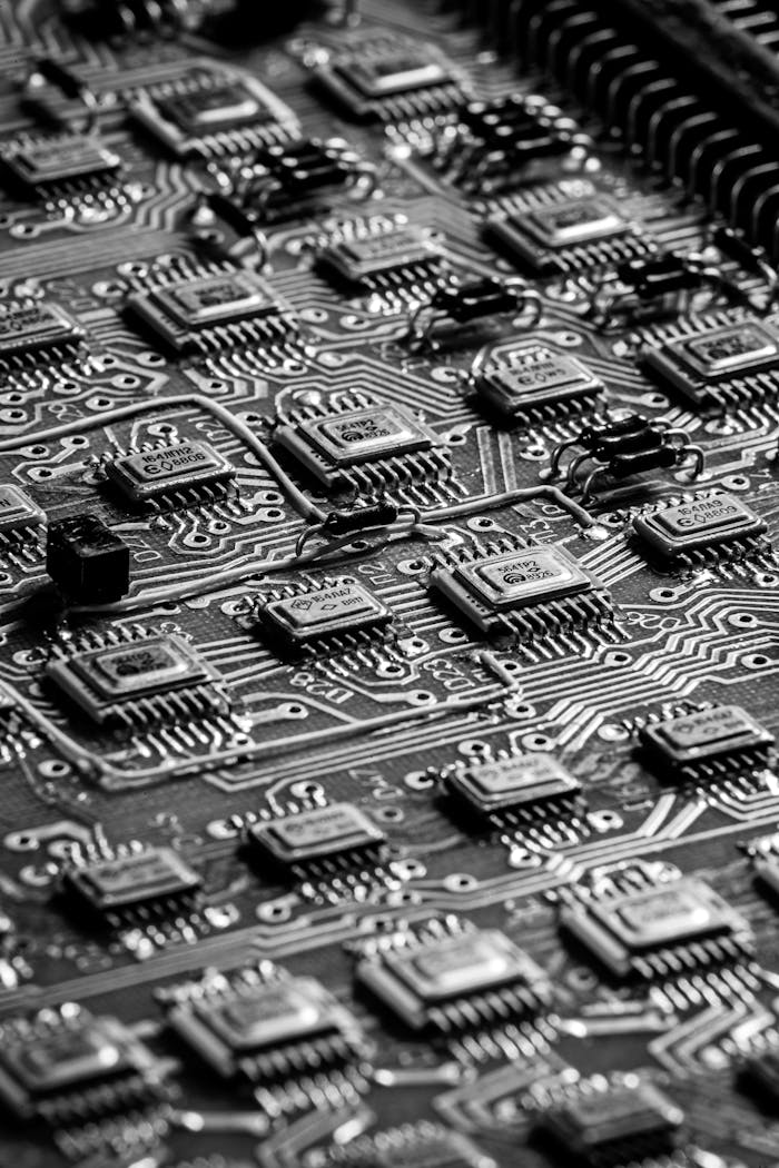 Close-up black and white image of a detailed circuit board, showcasing technological intricacies.